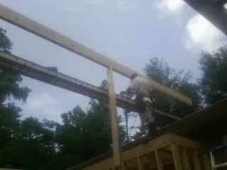 Carpenter setting a ridge beam over a new addition frame — Ice Dam Removal by Roofing Brothers in Wernersville