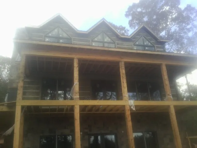 Dormers and porch framing on a large log home under construction — Roof Coating work by our crew in Wernersville